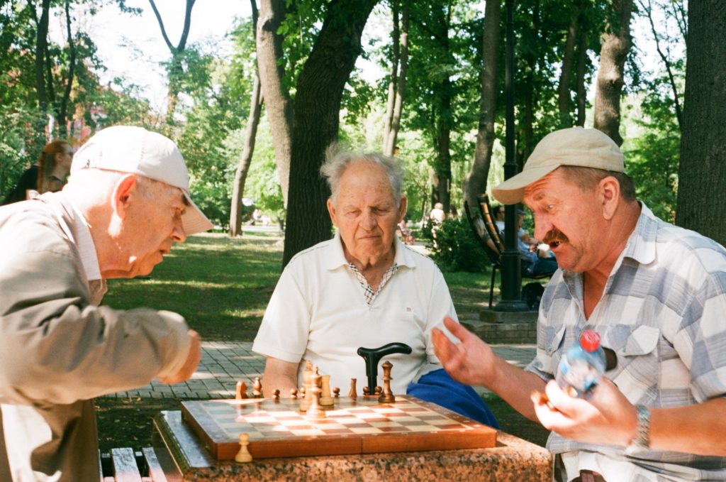 Elderly men playing chess in a park