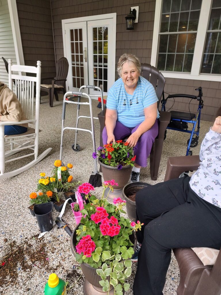 A Beaver Lake Lodge resident potting some brightly colored flowers