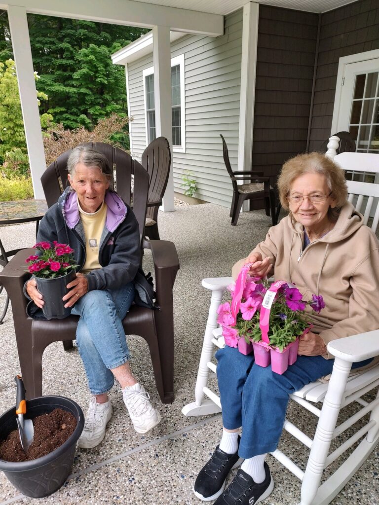 A couple of Beaver Lake Lodge residents holding some petunias