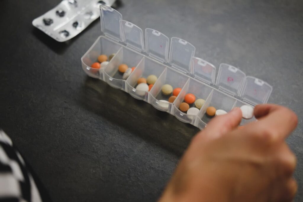 Person sorting pills in a pill sorter